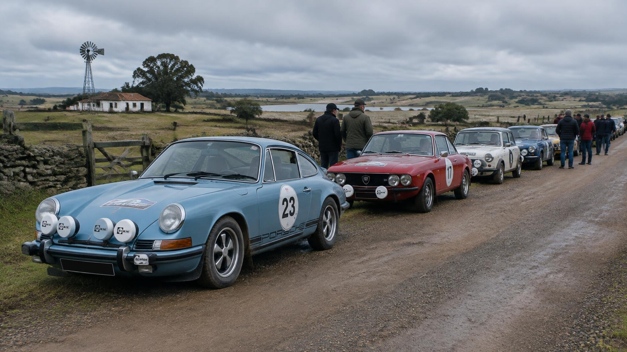Line of classic rally cars parked on a rural Uruguayan road during a vintage rally