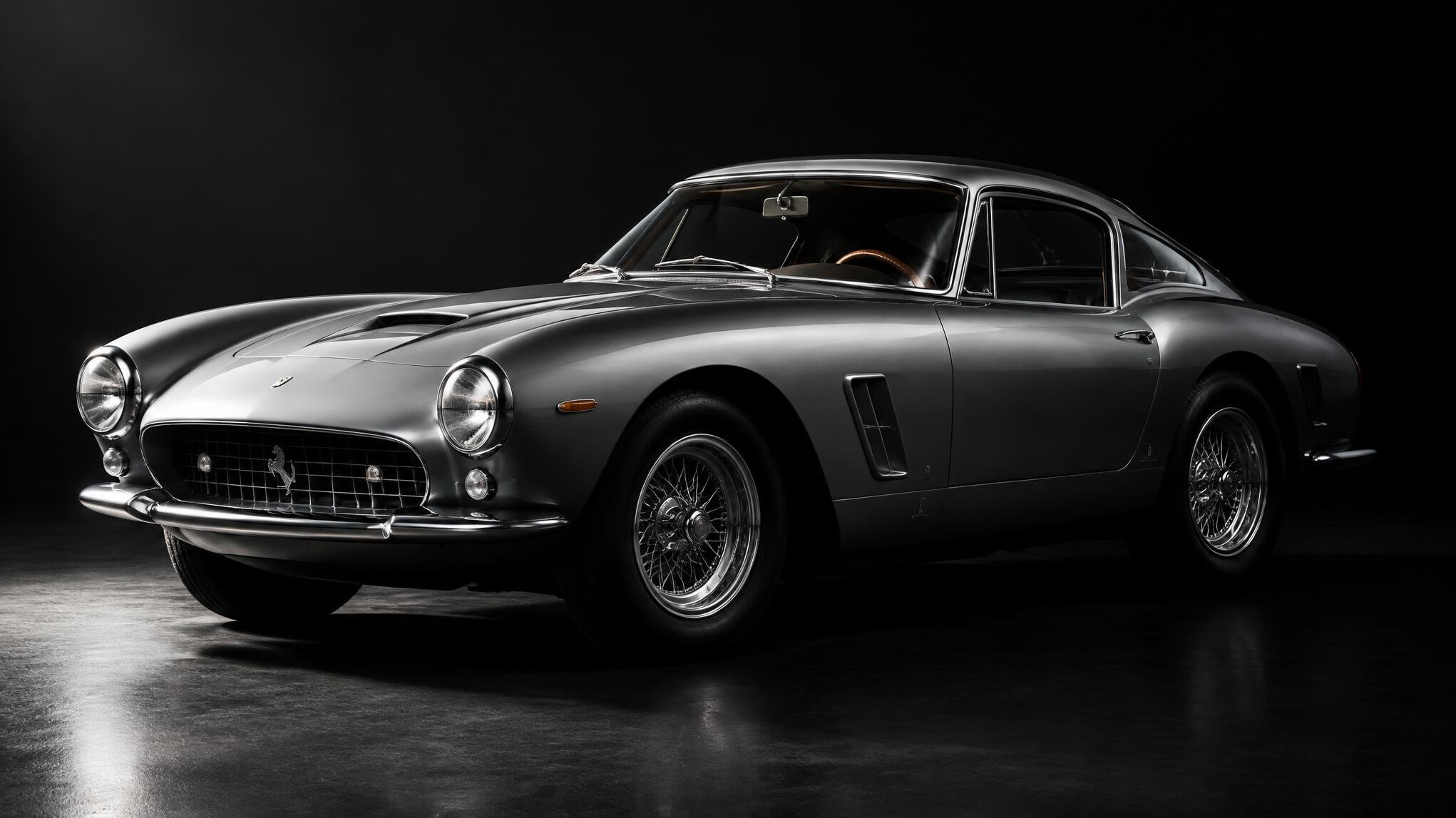 Restored 1960s European sports car photographed in dramatic lighting
